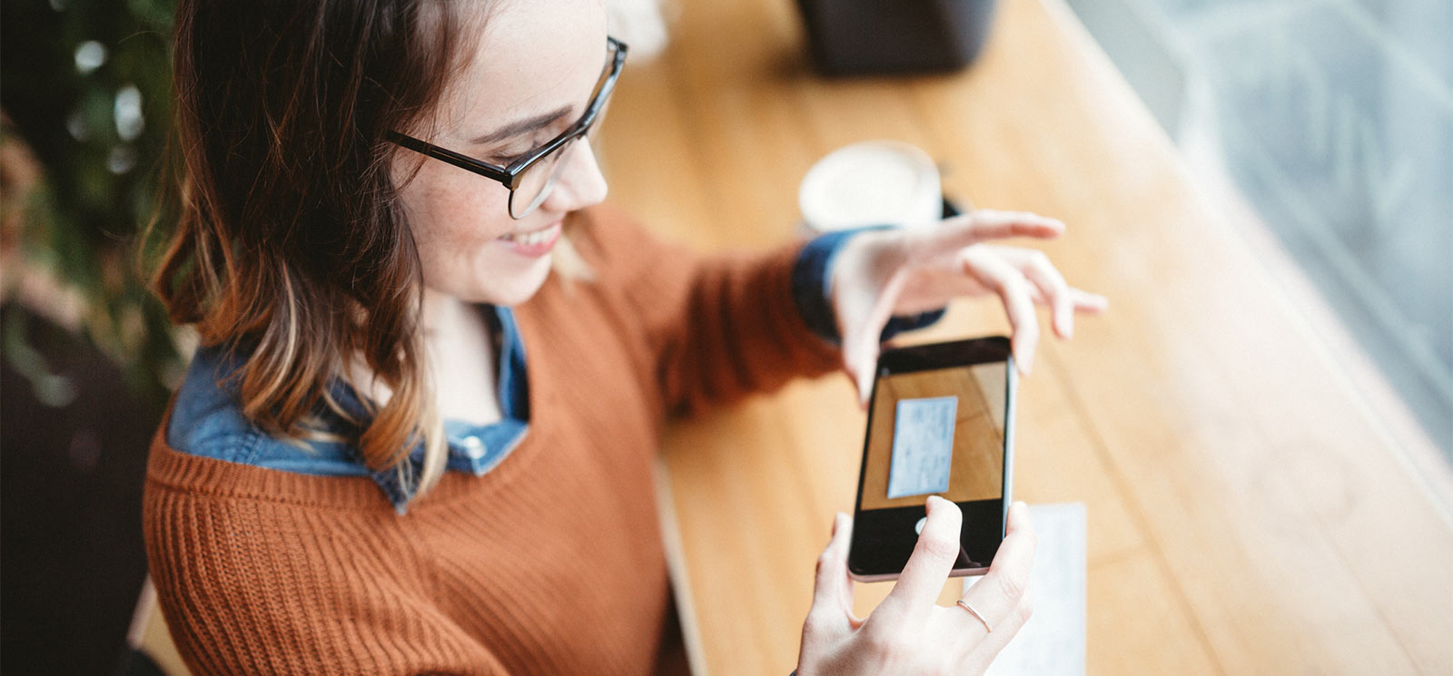 Young lady making a mobile deposit with her smartphone